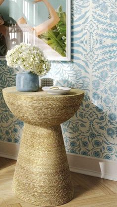 a vase with white flowers sitting on top of a table in front of a mirror