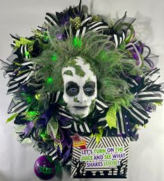 a white mask with green hair and decorations