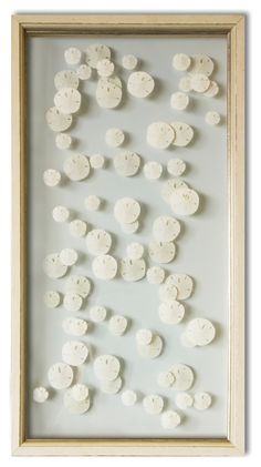 a white framed artwork with lots of buttons on it's side and the bottom frame