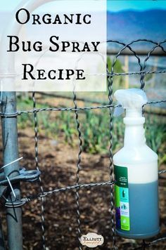 a bottle of organic bug spray sitting on top of a fence next to a wire fence