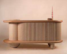 a wooden bench with a lit candle on top of it and a white wall in the background