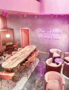 a room with pink chairs, tables and a sign that says coffee and friends are perfect blend