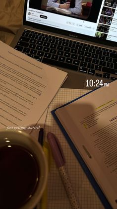 an open laptop computer sitting on top of a desk next to a cup of coffee