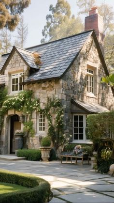 a stone house with lots of greenery around it