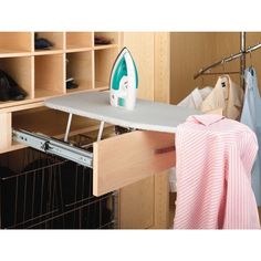 an ironing board and clothes hanging on a rack