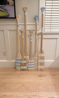 four wooden paddles are lined up against the wall