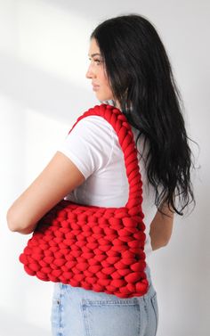 a woman carrying a red crocheted bag on her back with long black hair