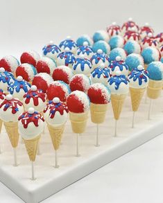 red, white and blue ice cream cones with sprinkles in them on a tray