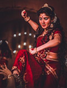 a woman in red and gold outfit dancing