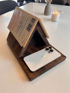 an iphone in a wooden stand on a table