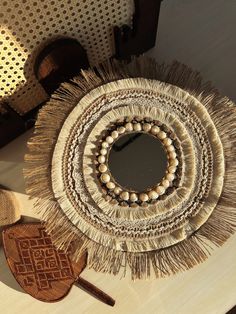 a round mirror sitting on top of a wooden table next to other items and decor