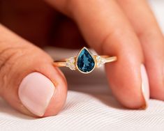 "Pear Cut London Blue Topaz Engagement Ring,14k Solid Gold Cluster Diamond Ring,Solitaire Proposal Ring,Delicate Jewelry,Elegant Promise Ring ★ ★ ★ ★  CUSTOM/DUTY-FREE SHIPPING WORLDWIDE, BUYERS DON'T HAVE TO PAY ANY CUSTOM FEES WHILE IMPORTING ★ ★ ★ ★  Details Made to order Material: 14k/18k Gold Color Options: Yellow Gold, White Gold, Rose Gold,  ★ Center Stone:  London Blue Topaz, Pear Size: 5 x 7 mm Approx Weight (Ct): 0.69 ★ Accent Stones:  Diamond/Moissanite, Round Size: 1.5 mm * 6 No.s Approx Weight (Ct): 0.084 ★ 100% Natural Diamond and Gemstones ★ Diamond: Round Brilliant cut, G-H Color, SI Clarity ☂ Shipped with Insured Shipping within 4-7 business days. ➦ 100% Free Returns. ➦ Our Jewelry comes with a Lifetime Warranty. (Stone Replacement not included) ✈ We offer free EXPRESS shi Luxury Promise Ring With Round Cut Topaz, Luxury Topaz Promise Ring With Accent Stones, Luxury Topaz Promise Ring With Prong Setting, Luxury Topaz Promise Ring With Diamond Accents, Luxury Topaz Promise Ring With Round Cut, Luxury Solitaire Topaz Promise Ring, Luxury Rose Cut Diamond Topaz Promise Ring, Luxury Polished Finish Topaz Promise Ring, Pear Cut Diamond Engagement Ring With Blue Topaz Sidestones