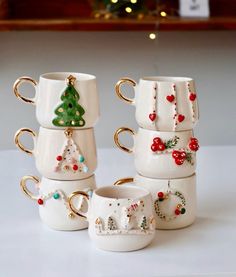 a stack of coffee mugs with christmas decorations on them