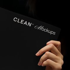 a close up of a person's hand holding a black folder with the word clean on it