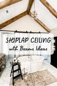 a white bath tub sitting inside of a bathroom next to a wooden beamed ceiling