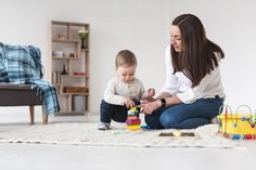 a woman playing with her baby on the floor