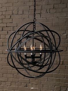 a chandelier hanging from a brick wall in front of a window with candles on it