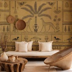 a living room filled with lots of furniture and wallpaper covered in egyptian designs on the walls