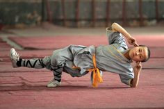 a young boy is doing a handstand on the ground with an inspirational quote