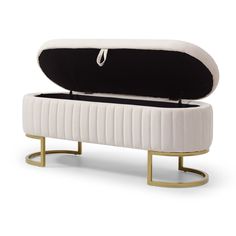 an upholstered bench with black and white cushioning on the top, gold metal base