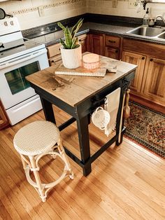 a small kitchen with an island table and stools