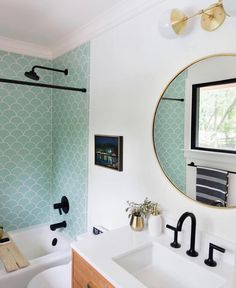 the bathroom is decorated with green and white wallpaper, black faucets, gold accents