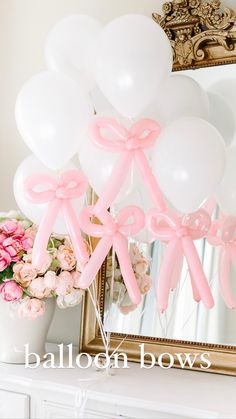 balloons are tied to the side of a mirror with pink bows on them and flowers