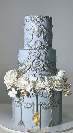 a blue wedding cake with white flowers on top