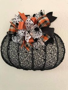 a black net bag with orange and white bows hanging on the side of a wall