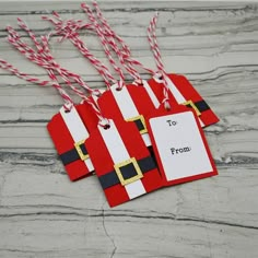 two santa clause tags with candy canes hanging from them