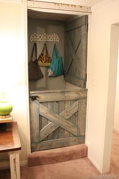 an open barn door with two purses hanging on the wall and a green vase next to it