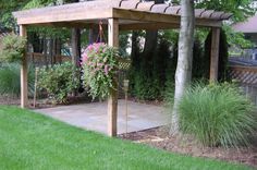 a wooden gazebo in the middle of a garden with lots of flowers on it