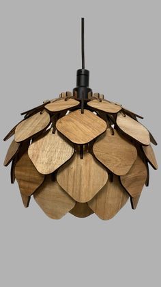 a wooden light hanging from the ceiling with lots of leaves on it's sides