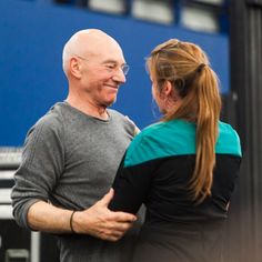 an older man and woman embracing each other