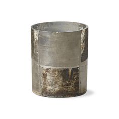 an old metal cup sitting on top of a white table