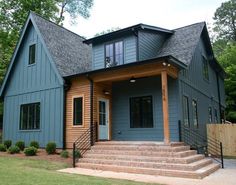 a blue house with steps leading up to the front door and second story porch area