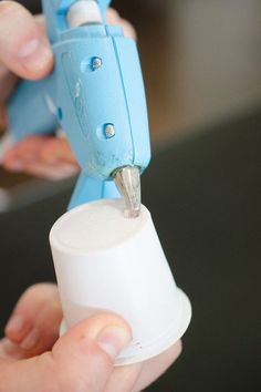 a person is holding a blue and white object in their left hand, while the other hand holds something