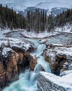 a frozen waterfall with snow on the ground