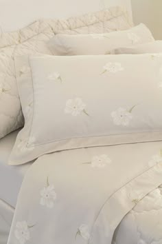 the comforter is made up with white flowers and ruffles on it's edges