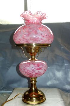 a pink and white lamp sitting on top of a table