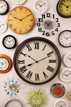 many different clocks are on the wall and one is showing five o'clock to six o'clock