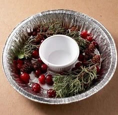 a bowl filled with cranberries and pine cones