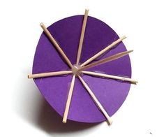 a purple paper plate with sticks sticking out of it