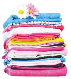 a stack of folded clothes with a flower on the top and one pink flower in the middle