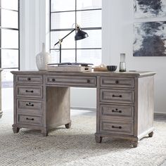 an office desk with drawers and a lamp