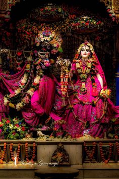 two women dressed in pink and gold are standing next to each other