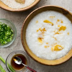 two bowls filled with rice and vegetables on top of a table next to spoons