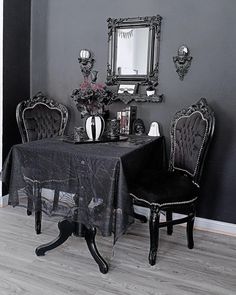 a dining room table with two chairs and a black table cloth draped over the table