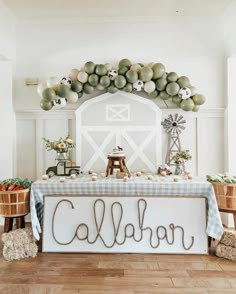 a table with balloons and decorations on it in front of a sign that says calabr