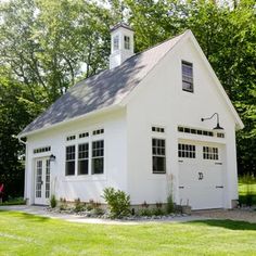 a small white house with a clock tower